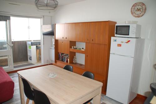 une cuisine avec une table et un réfrigérateur blanc dans l'établissement Vue mer les Becs Saint Hilaire, à Saint-Hilaire-de-Riez