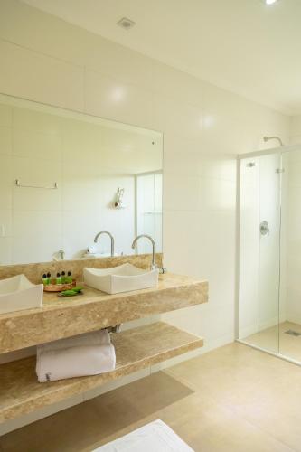 a bathroom with two sinks and a shower at Casablanca Hotel Boutique in Campos do Jordão