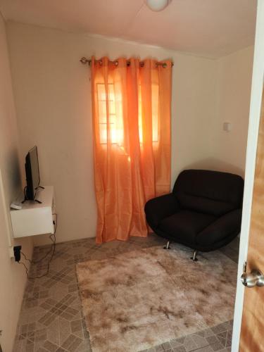a living room with a couch and a window at Valdu Cozy Cottage in Christ Church