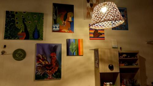 a wall with pictures of chickens and a light fixture at Vila Flexal Pousada in Alter do Chao