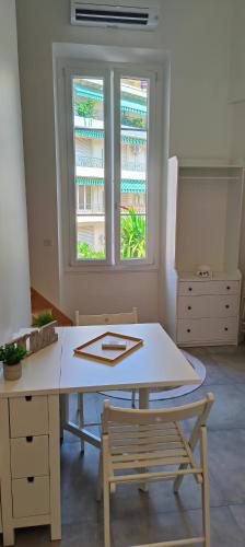 une table et une chaise dans une pièce avec une fenêtre dans l'établissement PLEIN SUD - moderne studio avec mezzanine- Hyper centre Antibes - Proche port, à Antibes