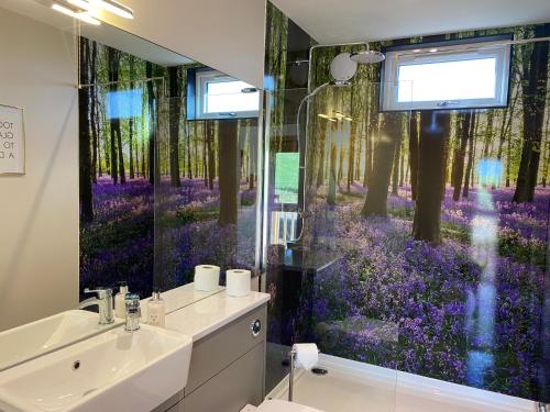 a bathroom with a large window with purple flowers at Acorn Lodge with Hot Tub in Cupar
