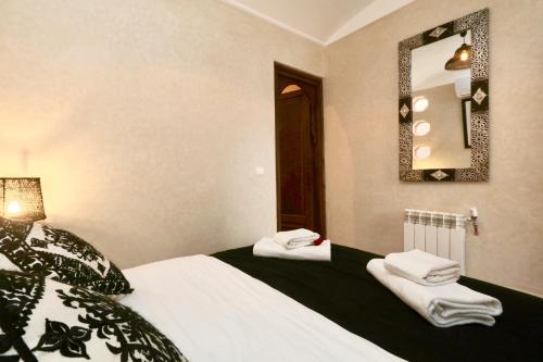 una camera da letto con un letto con lenzuola bianche e uno specchio di Riad Beata Bed & Breakfast a Marrakech