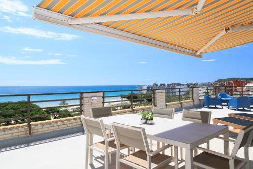 a balcony with a table and chairs and the ocean at UHC CASPEL APARTMENTS in La Pineda