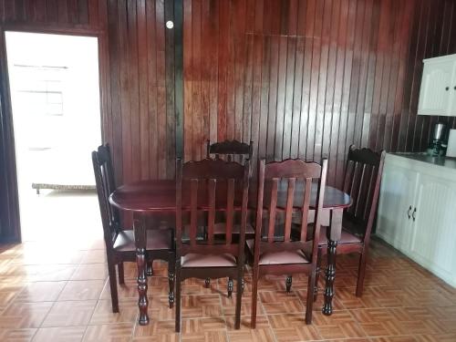 comedor con mesa de madera y sillas en Belle Breeze Cottage en Gros Islet