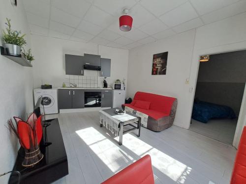 uma sala de estar com um sofá vermelho e uma mesa em Appartement cosy sur Masevaux em Masevaux