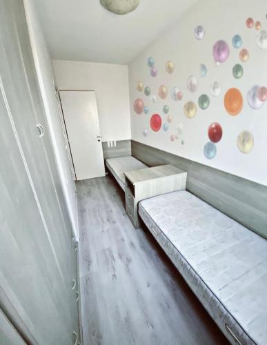 een kamer met 2 bedden en een muur met borden bij [SolMare] Apartments - Private parking - Pool in Rosapineta