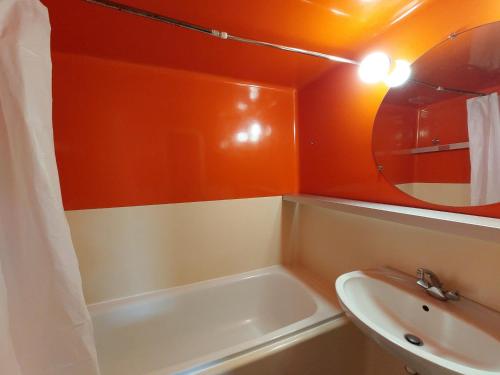 une salle de bain avec une baignoire, un lavabo et un miroir dans l'établissement 2 pièces skis aux pieds près de l'ESF et commerces - FR-1-411-780, à Bourg-Saint-Maurice