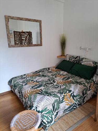 - une chambre avec un lit doté d'une couverture colorée et d'un miroir dans l'établissement Studio chic, hyper centre, 4 minutes de la plage, à Cabourg