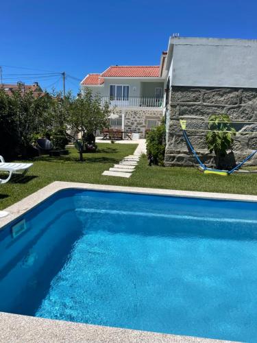 a swimming pool in front of a house at Casa do Albano in Viana do Castelo