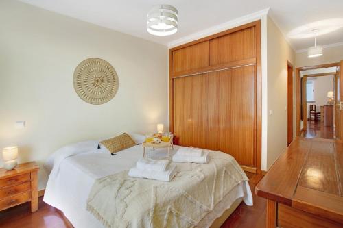 een slaapkamer met een bed met twee handdoeken erop bij Apartamento Fénix Garajau in Caniço
