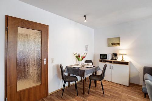 a dining room with a table and chairs and a door at Appartement Arend in Dobel