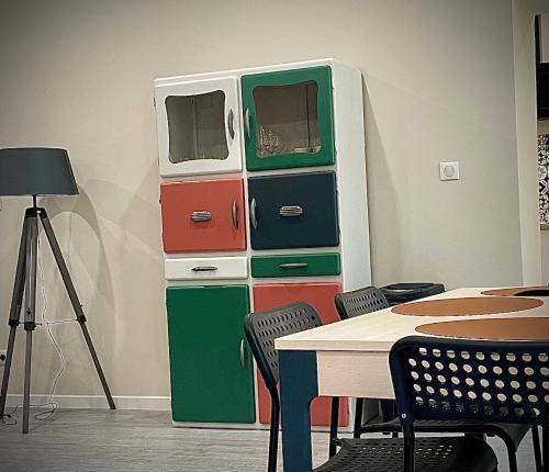 a room with a table and some colorful drawers at Gîte les Pissenlits centre historique Saint-Astier in Saint-Astier