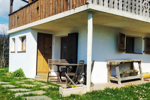 a blue and white house with a table and chairs at New studio ground floor in the heart of nature in Châtillon-sur-Cluses