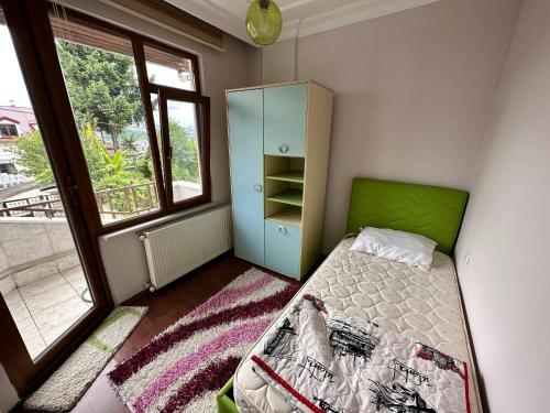 a small bedroom with a bed and a cabinet at Peaceful Villa with Perfect View in the City Center in Trabzon