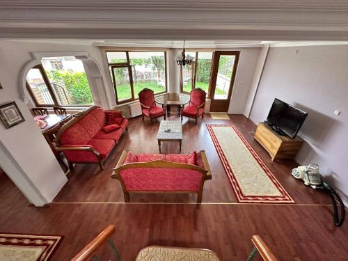 a living room with red chairs and a table at Peaceful Villa with Perfect View in the City Center in Trabzon