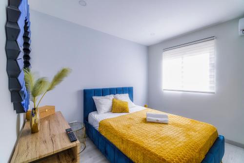 um quarto com uma cama com uma cabeceira azul e uma janela em Palangre Beach Apartment em Torrevieja