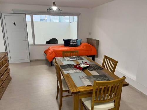 a bedroom with a table and a bed with orange sheets at apart trelew 1 in Trelew