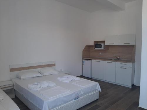 sypialnia z białym łóżkiem i kuchnią w obiekcie Апартаменти Жени w Carewie