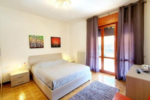 Schlafzimmer mit einem Bett und einem Fenster mit lila Vorhängen in der Unterkunft NIKO apartment in Santo Stino di Livenza