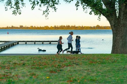 a group of people walking their dogs by a lake at Ballarat Modern Oasis, Stylish 3 bedroom 2 bathroom Retreat, Newly build, New appliances, beds and furniture, Walking distance to Shopping mall in Ballarat