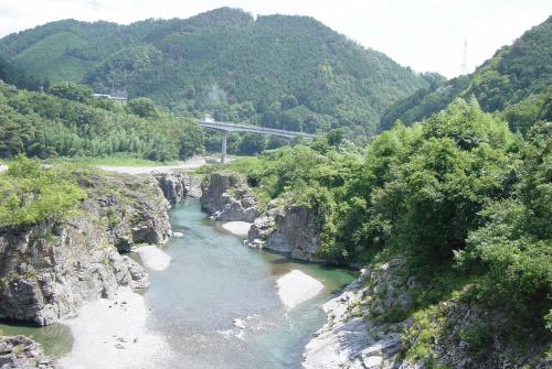 a river with a bridge in the middle of a mountain at Fukubatake in Yoshino