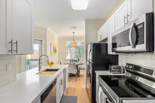 a kitchen with white cabinets and a black refrigerator at Miller Road 207A townhouse in Scottsdale