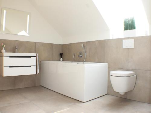 a bathroom with a white tub and a toilet at Sonnengarten 21 in Kellenhusen