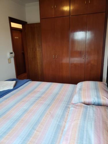 a bedroom with a bed and wooden cabinets at Pousada Monte Sião in Sao Paulo