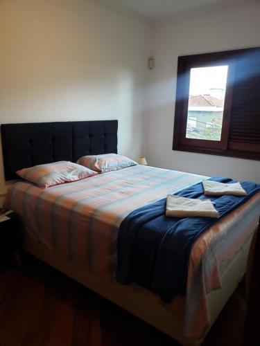a bed with two towels on it in a bedroom at Pousada Monte Sião in Sao Paulo
