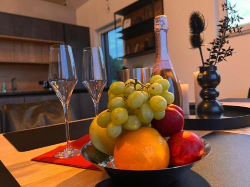 a bowl of fruit on a table with wine glasses at Chalet Panorama in Freyung