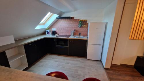 une petite cuisine avec un évier et un réfrigérateur dans l'établissement La Cigogne, à Château-Thierry