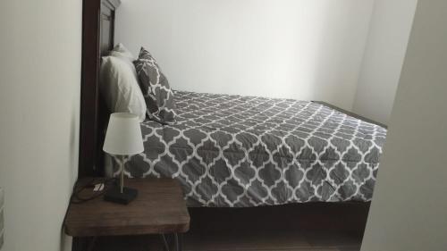 a bedroom with a bed with a mirror and a lamp at Lovely and Peaceful Home in Guatemala