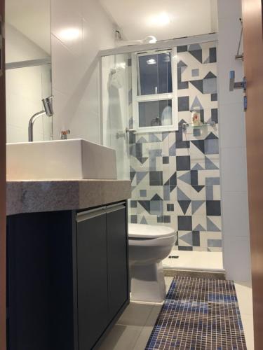 ein Badezimmer mit Waschbecken und Toilette in der Unterkunft Apto Luxo frente praia do Morro in Guarapari