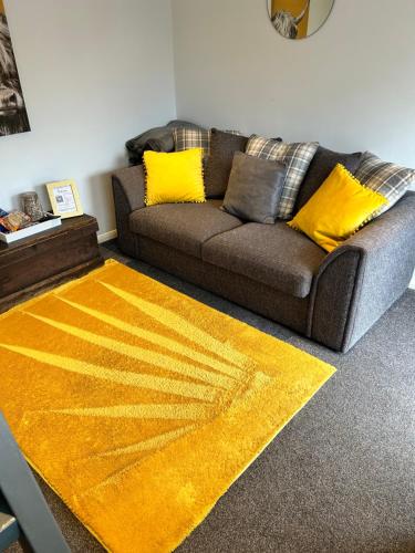 sala de estar con sofá y alfombra amarilla en The Bubble Hideaway - A Little Oasis near the Sea, en Whitstable