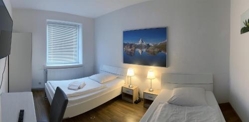 Cette petite chambre comprend 2 lits et 2 lampes. dans l'établissement Apartment Donau, à Hanovre