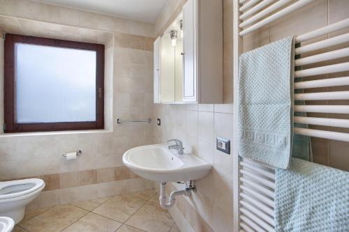uma casa de banho com um lavatório, um WC e uma janela. em Appartamento Bormetti Paolo Sara em Livigno