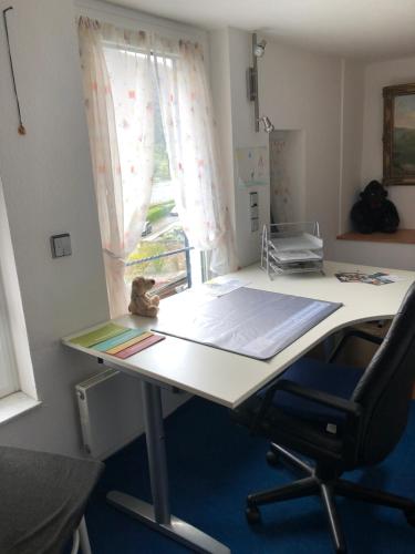 ein Büro mit einem Schreibtisch mit einem Stuhl und einem Fenster in der Unterkunft Privatzimmer im 2. OG (Mansarde) mit Klimaanlage und schnellem Telekom-WLAN in Einfamilienhaus in Winningen