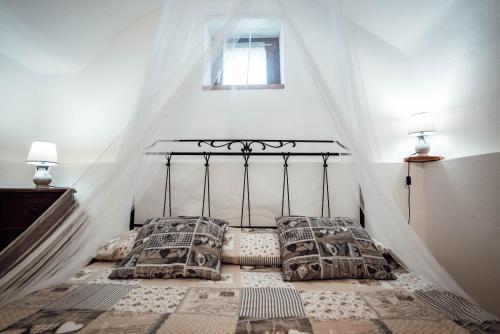 a bedroom with a canopy bed with pillows at Corte Isabel in Costermano