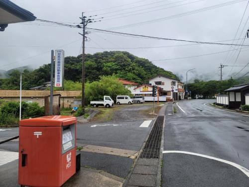 an empty street with a trash can on the side of the road at 하루카오후나에 민숙 in Tsushima