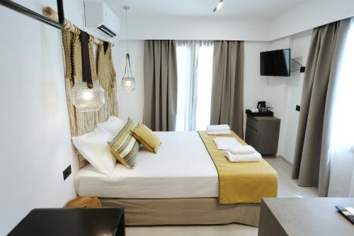 a bedroom with a large bed with yellow sheets and pillows at Yianna Hotel in Skala