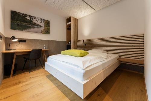 een slaapkamer met een bed, een bureau en een tafel bij Aparthotel nah dran in Dingolfing