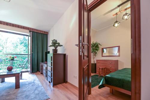 a bedroom with a bed and a door to a balcony at Apart4You Apartamenty Bulwary25 in Zakopane