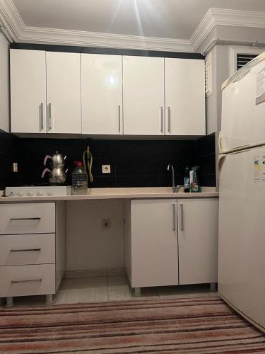 uma cozinha com armários brancos e um frigorífico branco em Comfort house Van em Van