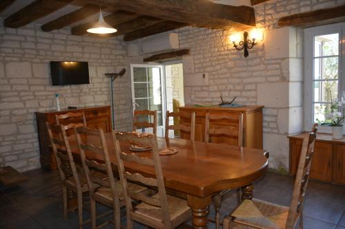une salle à manger avec une table et des chaises en bois dans l'établissement gite en touraine climatise, à Assay
