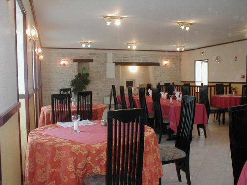 une salle à manger avec des tables, des chaises et un tissu de table rouge dans l'établissement Les Lilas Des Deux Ponts, à Cravant