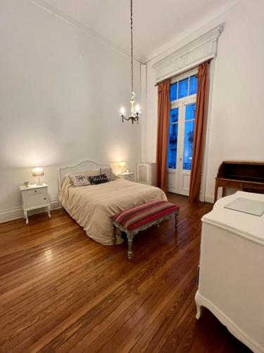 a white bedroom with a bed and a window at Refugio Francés en Buenos Aires in Buenos Aires
