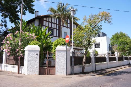 ein Haus mit einem Zaun und Blumen auf einer Straße in der Unterkunft Casa El Rincón in La Laguna