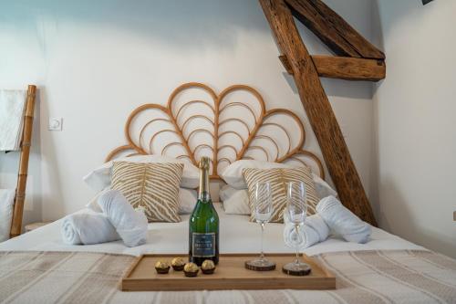 a bed with a bottle of wine and two glasses at BALI ROOM / Magnifique studio évasion JACCUZI in Montgeron