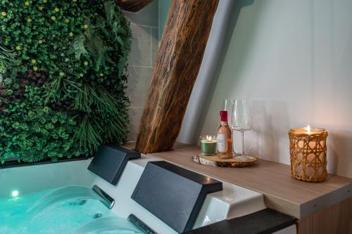 La salle de bains est pourvue d'une baignoire avec une table et des bougies. dans l'établissement BALI ROOM / Magnifique studio évasion JACCUZI, à Montgeron